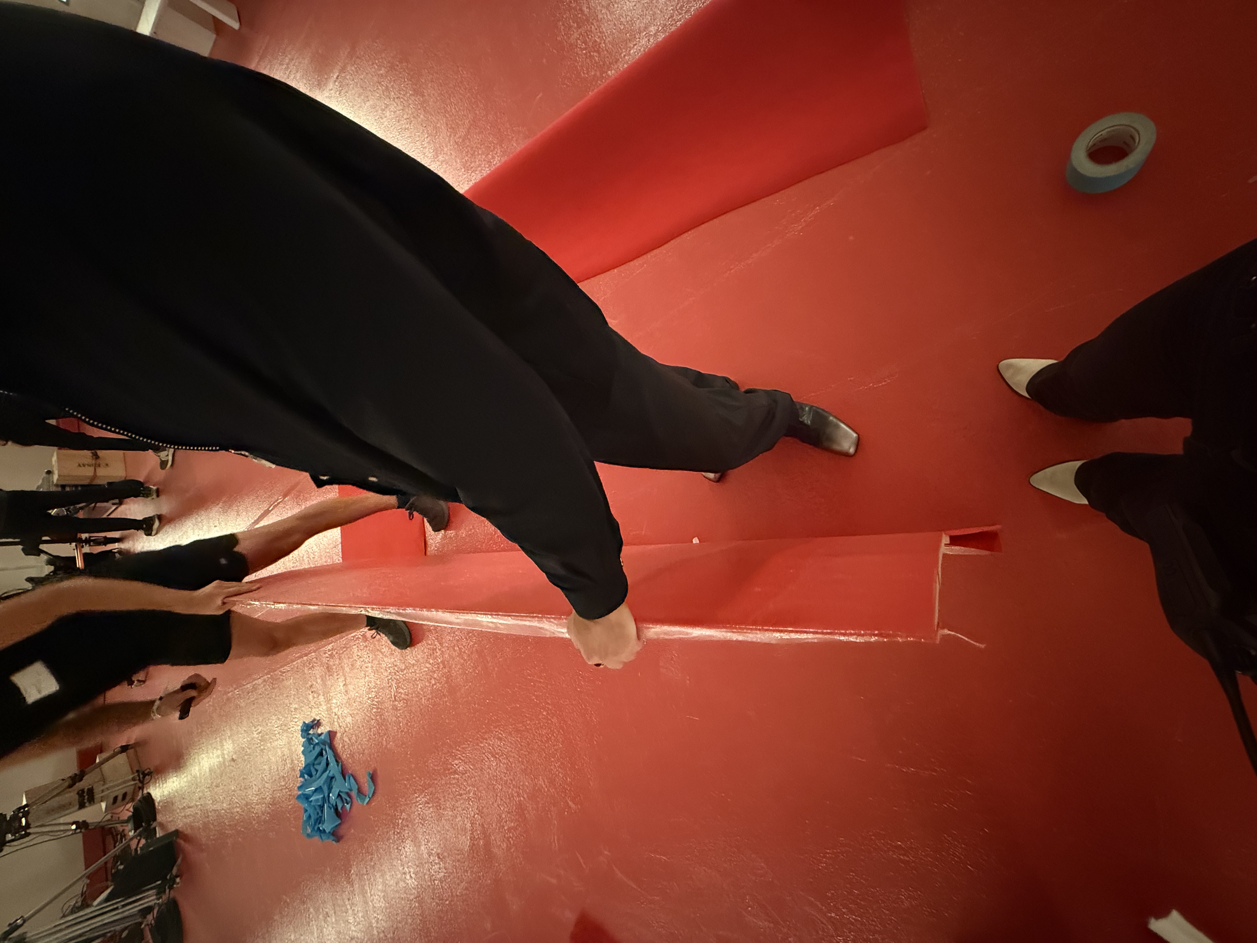 Detail of the red runway edge during install, with tape and crew nearby.