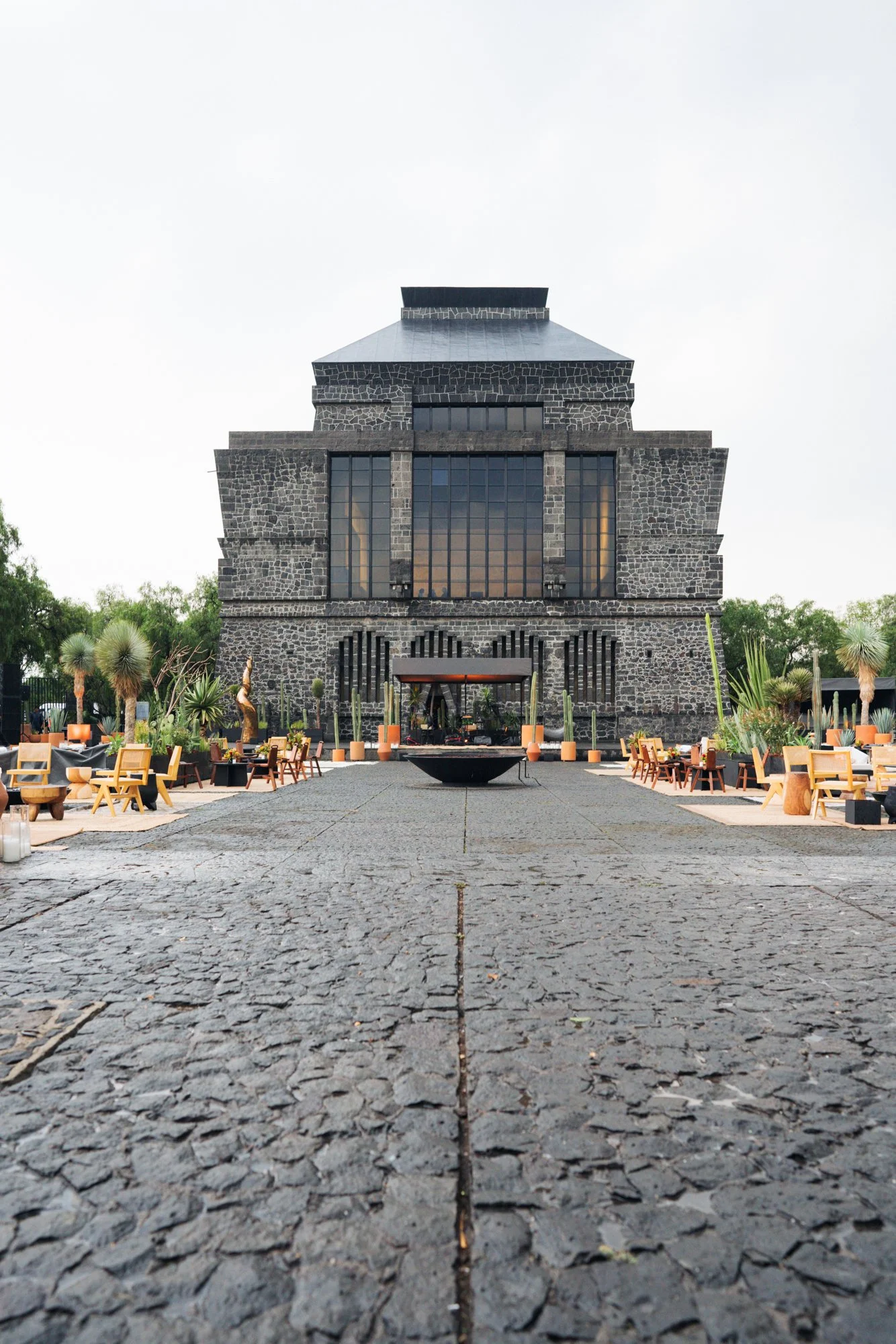 Symmetrical daytime view of Museo Anáhuacalli's stone facade, straight down the cobblestone courtyard path.