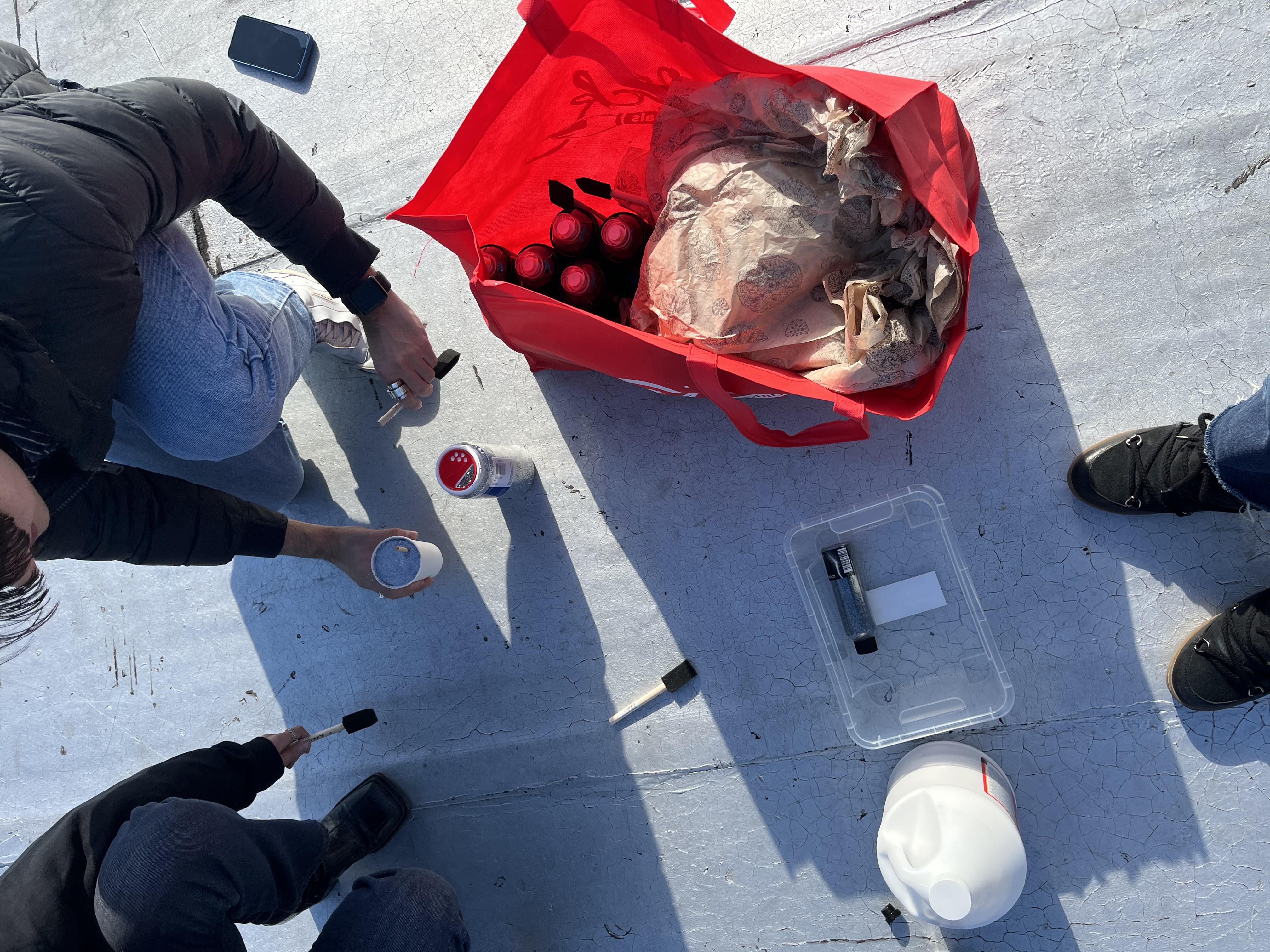Production team on the rooftop with glitter, glue and brushes laid out for the install.