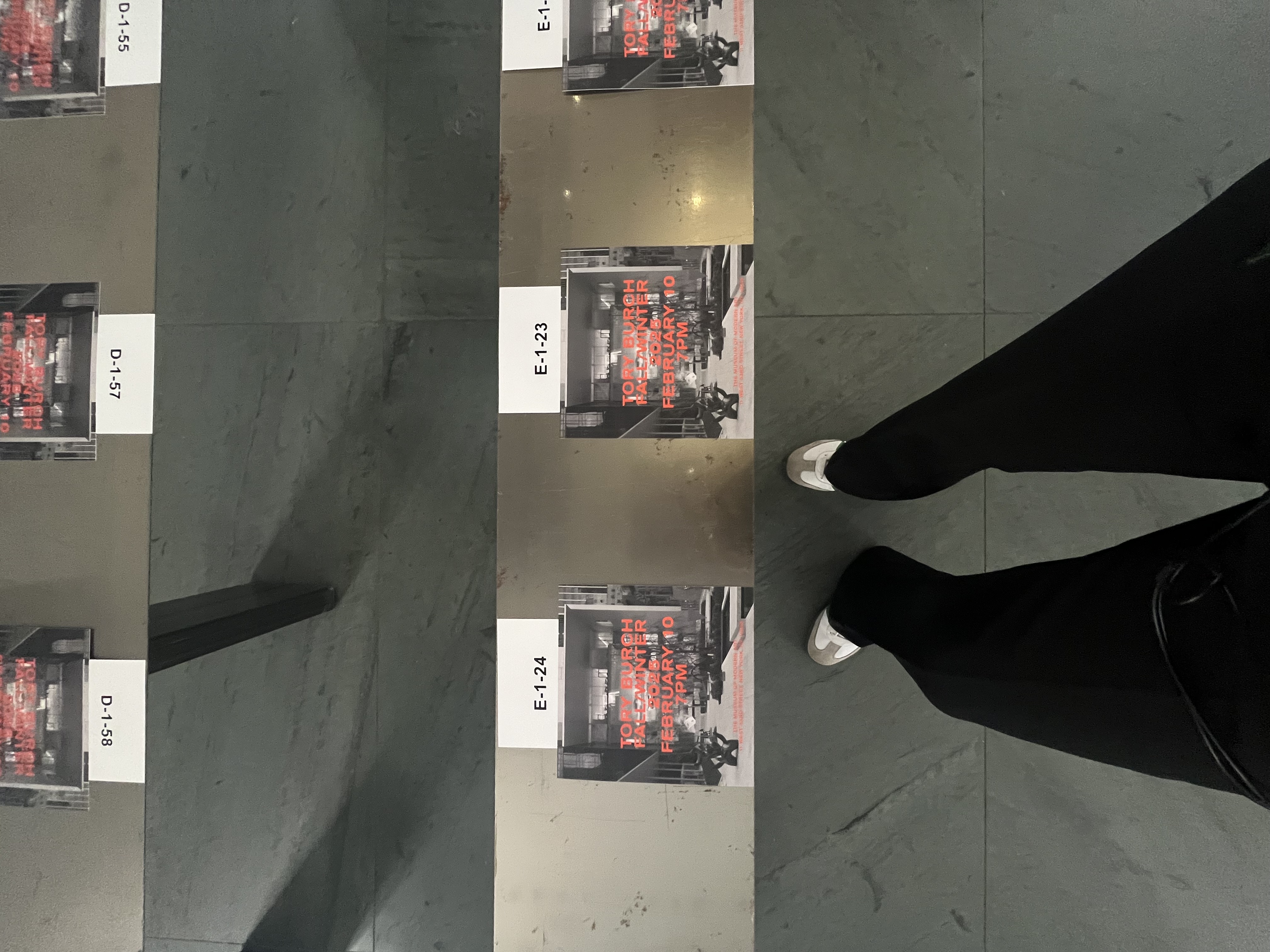 Close-up of a seat card marked E-1-23, Tory Burch Fall/Winter 2026, February 10, 7PM.